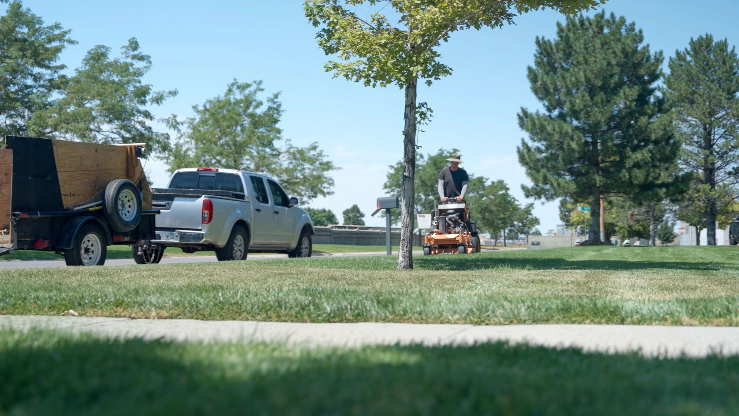 Groundskeeper mowing a residential lawn